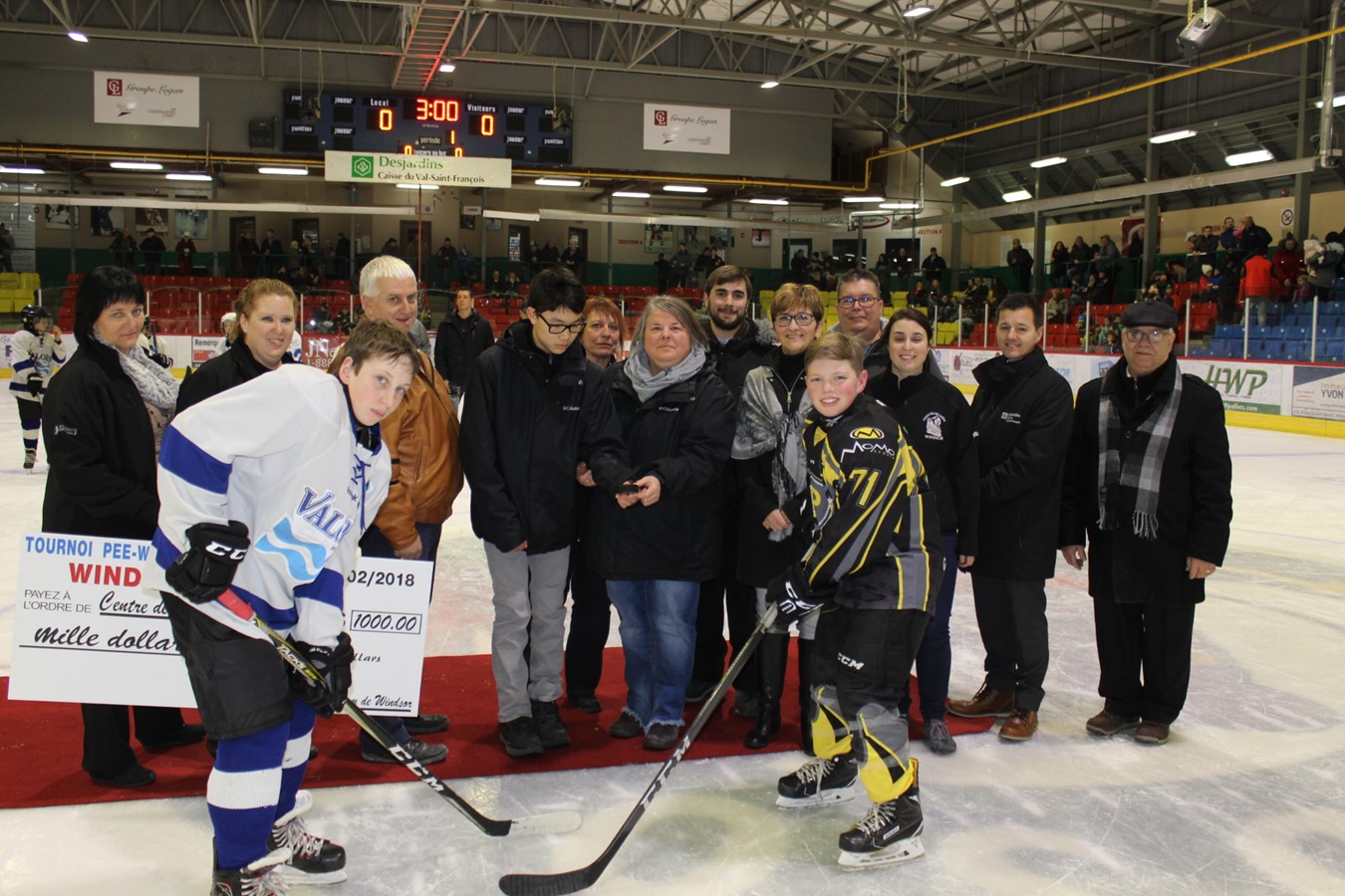 La mise en jeu protocolaire de l’inauguration de la 41e édition avait  réuni la présidente d’honneur Roxanne Vallières, au centre de la photo, accompagné des membres du comité organisateurs, invités et partenaires en présence des capitaines du Valois d’Acton-Vale et du Promutuel du Val-Saint-François.  