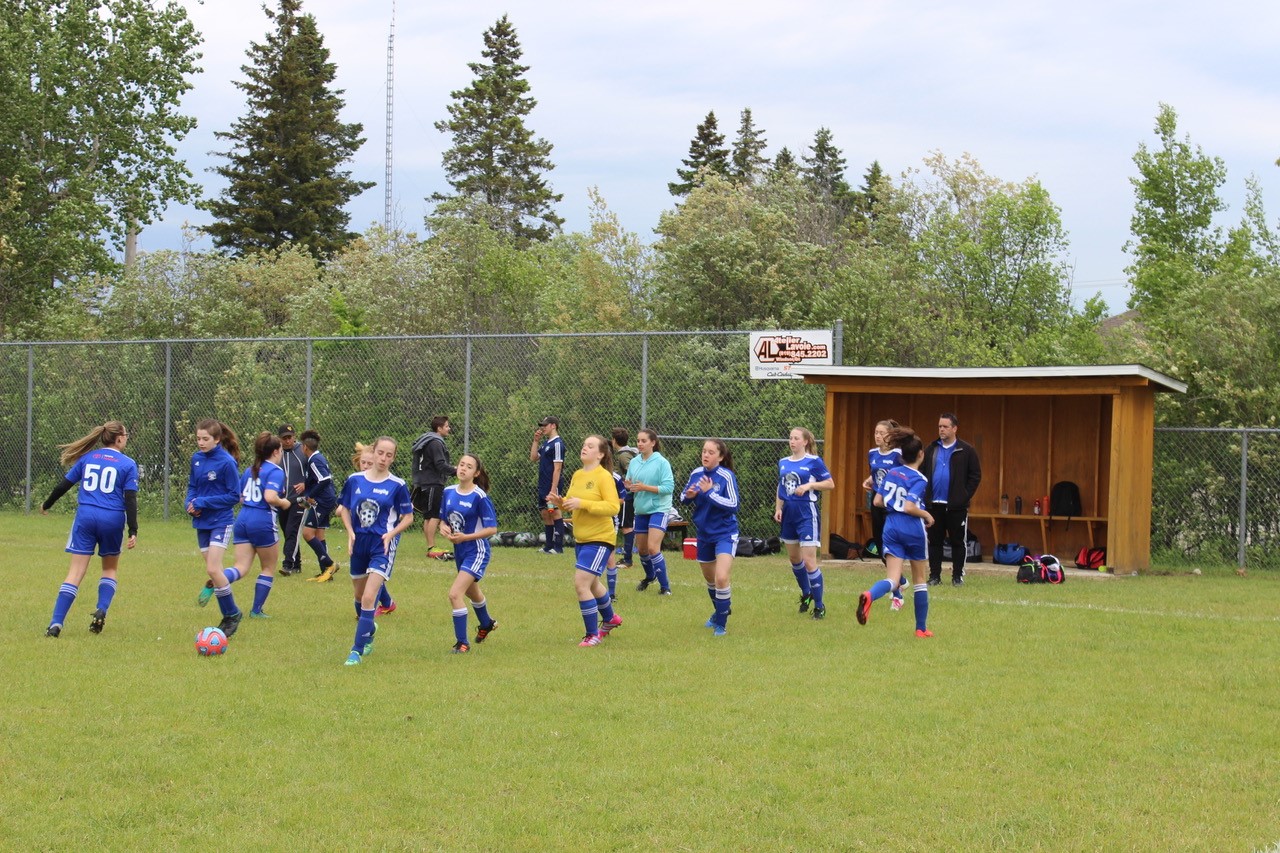 Une photo sur laquelle apparaissent joueuses et entraineurs à l’amorce du départ de la saison.