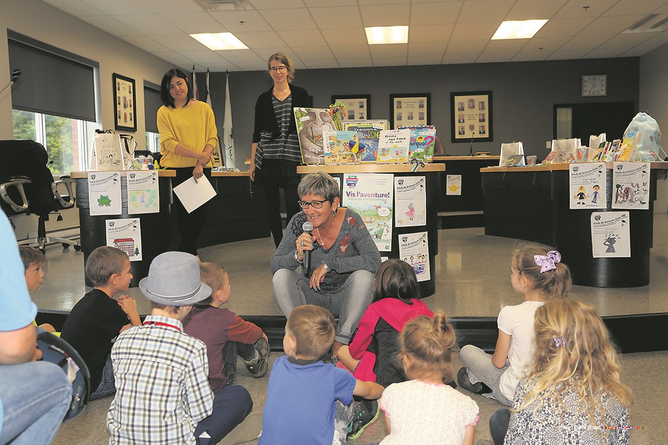 La mairesse Sylvie Bureau qui s’adresse aux enfants. Également, à l’arrière, la conseillère municipale Ana Rosa Mariscal et l’aide-bibliothécaire Caroline Pleau.
