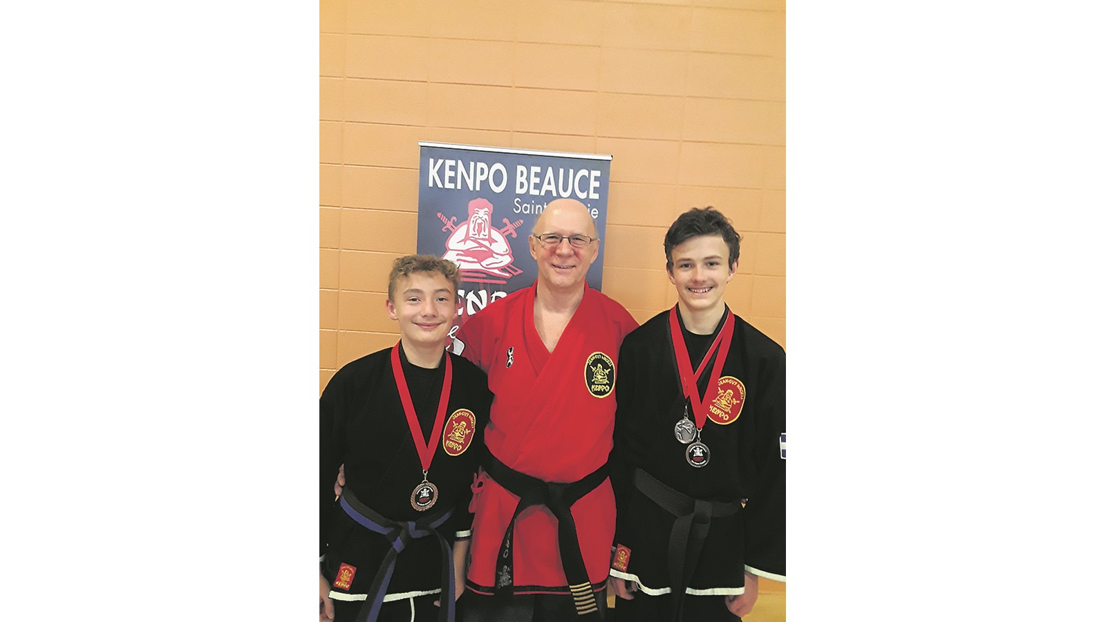 Le Senseï Guy Béliveau au centre,  pose en compagnie des jeunes karatékas médaillés, Dilan Bouchard et Colin Picard
