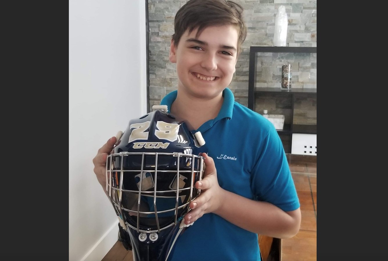 Hugo qui pose fièrement avec le casque peint aux couleurs de son dessin