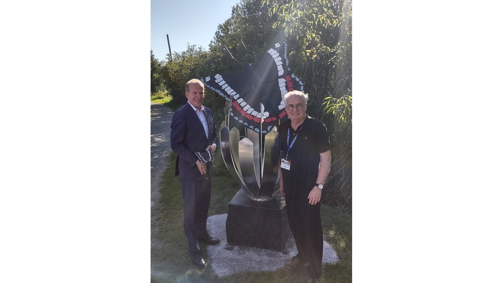 André Bachand, candidat de la CAQ et député sortant du comte de Richmond, accompagné du sculpteur Rénald Gauthier, posant tous deux devant l’oeuvre de ce dernier, le Papillon Amiral du Québec.